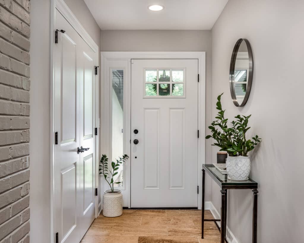 A cozy entryway with brown walls and a white front door. how to choose foyer paint color