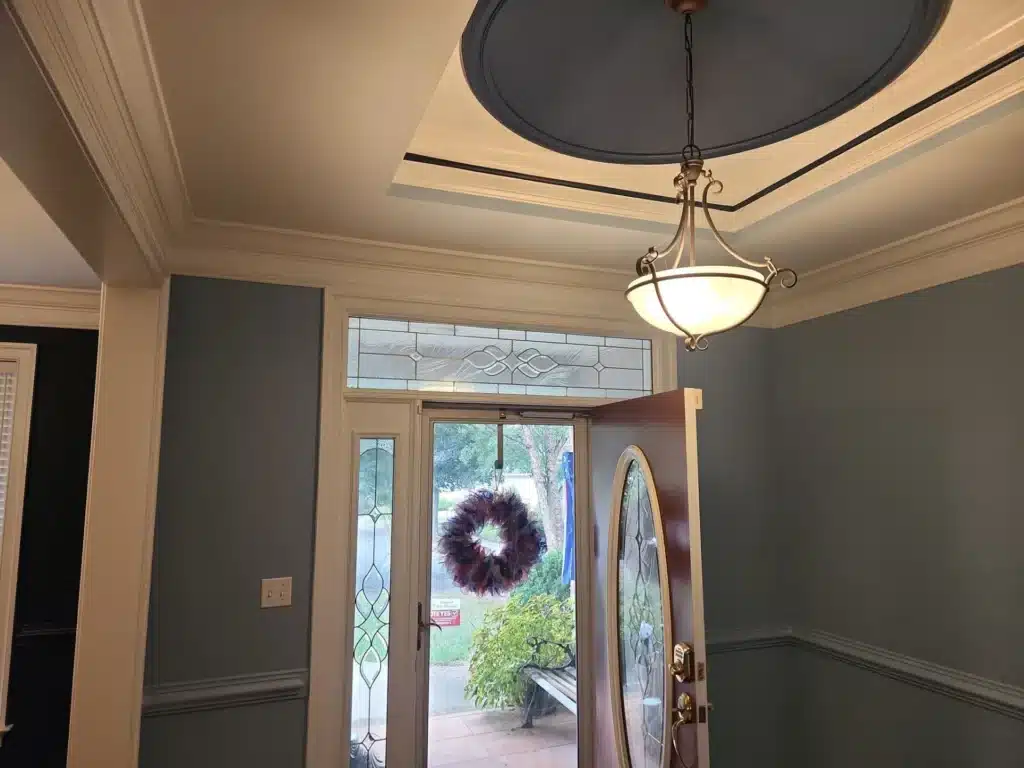 Gray Residential Entryway Painting Gray-painted residential entryway with cream ceiling, dark pendant light fixture, leaded glass doors, and white trim.
